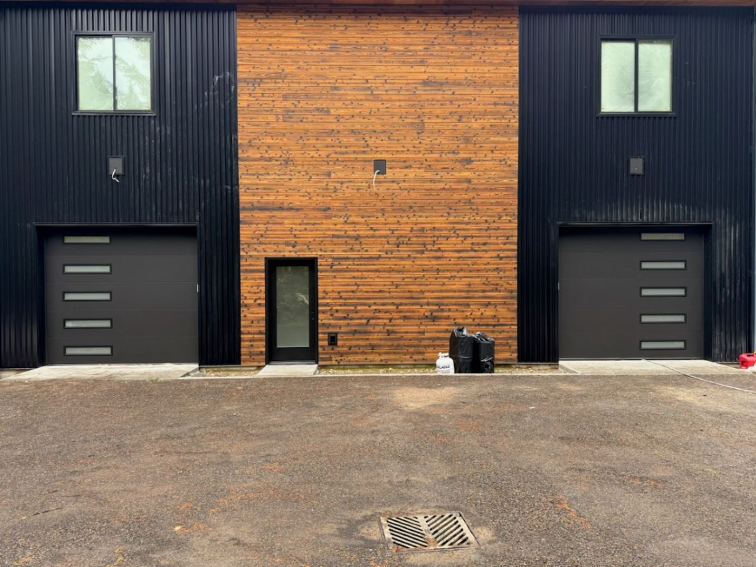 A modern wood garage door in good shape with a driveway in front