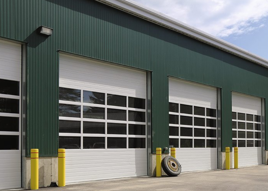 White commercial garage doors on a warehouse | commercial garage door solutions