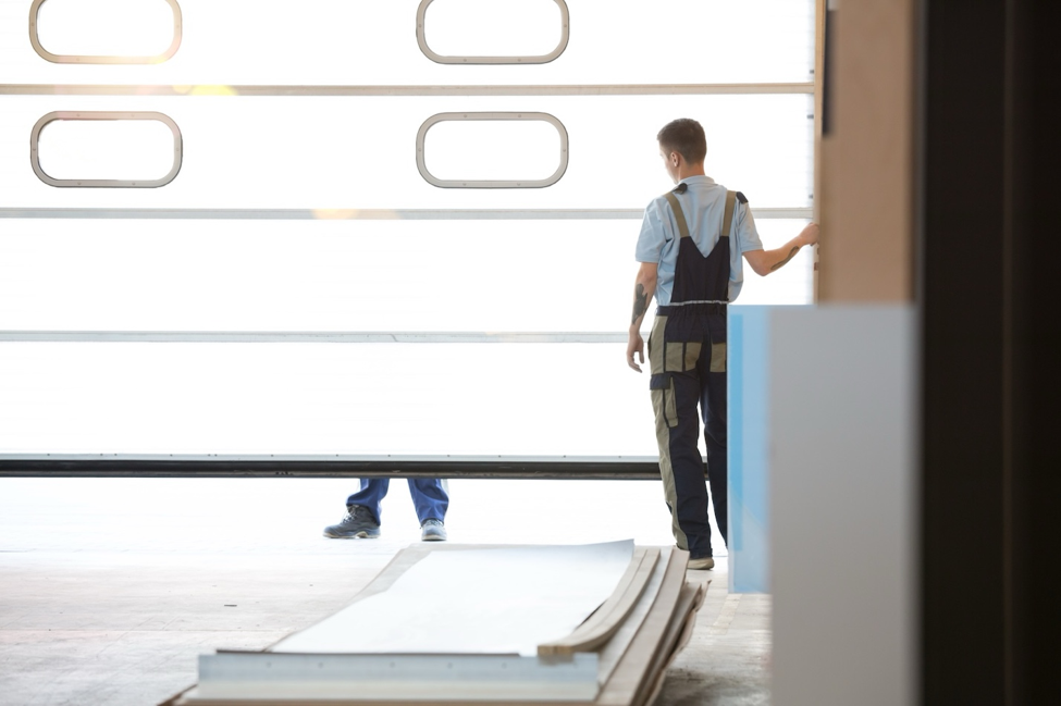 A man putting up a commercial garage door 