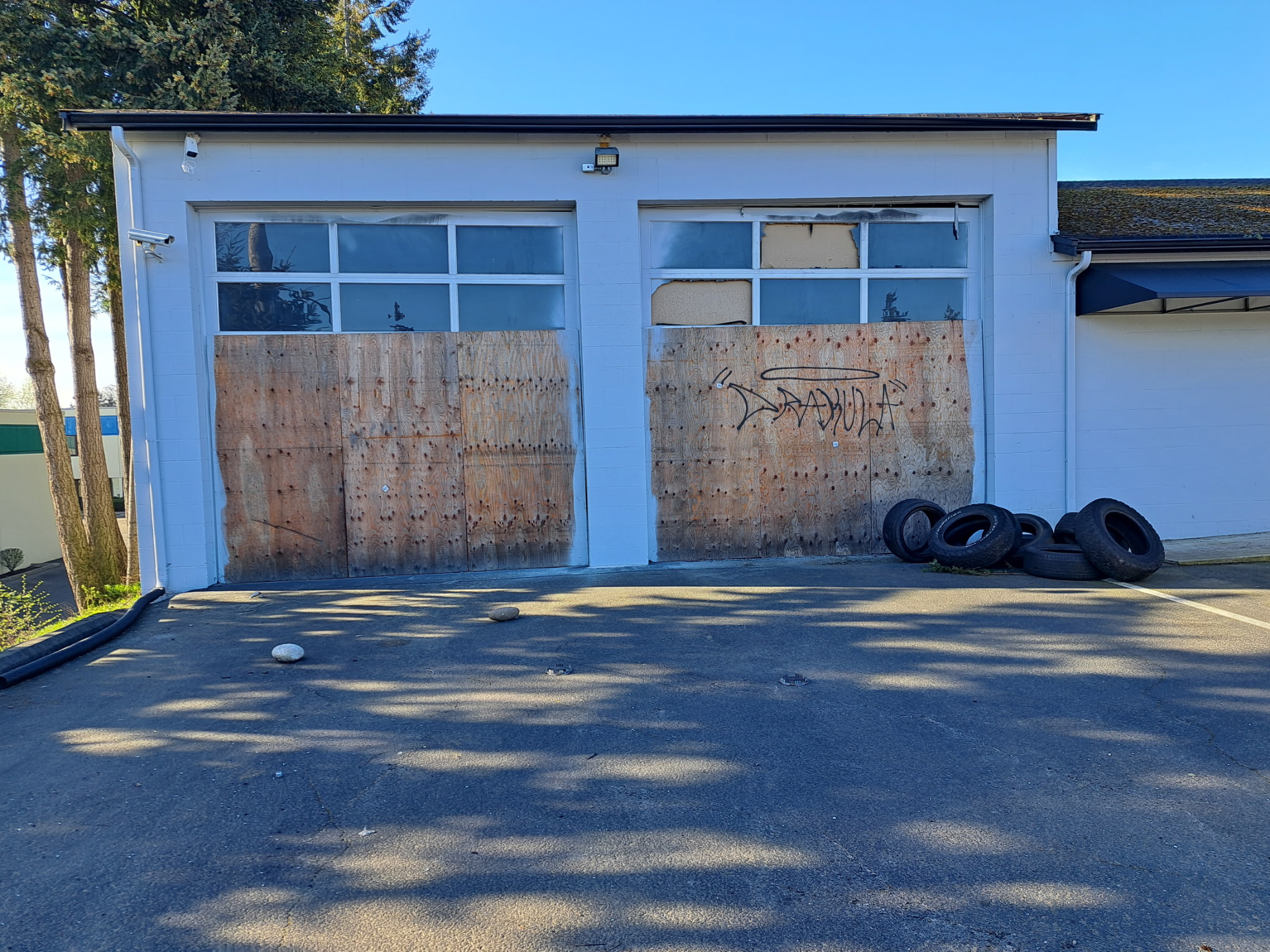 Repair run down garage doors with wooden panels and graffiti on them