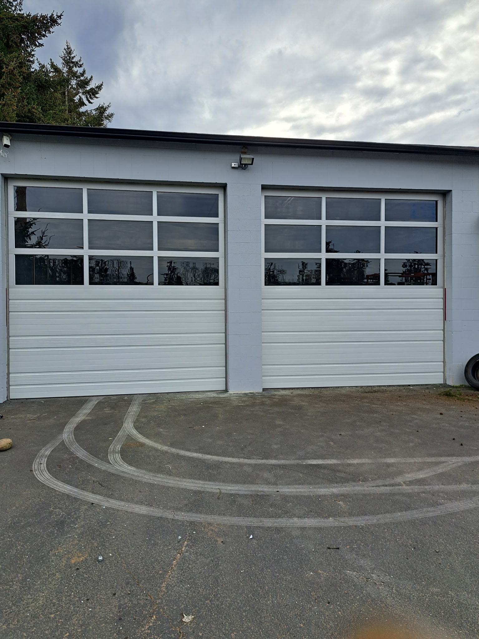 Newly repaired garage doors with windows and new paint